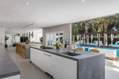 an open kitchen and dining room with a pool at Cypress Cabana Chateau Luxury Vacation Villa in San Diego