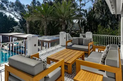 a patio with tables and chairs next to a pool at Cypress Cabana Chateau Luxury Vacation Villa in San Diego