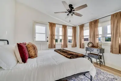 a bedroom with a white bed with a ceiling fan at The Stanton Residence - Chic and Cozy Classic near Downtown in San Diego