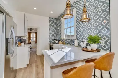 a kitchen with a counter and two chairs in it at The Stanton Residence - Chic and Cozy Classic near Downtown in San Diego