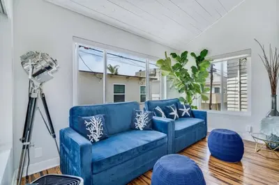 a blue couch in a living room with a camera at Sea house at Sea shore - 4 bedroom 3 bath - 14 ppl in San Diego