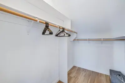 a walk in closet with white walls and a wooden rail at Sea house at Sea shore - 4 bedroom 3 bath - 14 ppl in San Diego