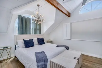 a bedroom with a large bed and a chandelier at Sea house at Sea shore - 4 bedroom 3 bath - 14 ppl in San Diego