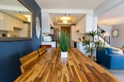 a living room with a wooden table and a blue couch at Cali Condo+BBQ+MemoryFoamBeds+12min to Beach in San Juan Capistrano