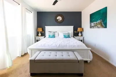 a bedroom with a large white bed with blue pillows at Cali Condo+BBQ+MemoryFoamBeds+12min to Beach in San Juan Capistrano