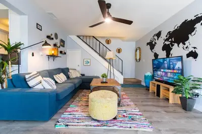 a living room with a blue couch and a tv at Cali Condo+BBQ+MemoryFoamBeds+12min to Beach in San Juan Capistrano
