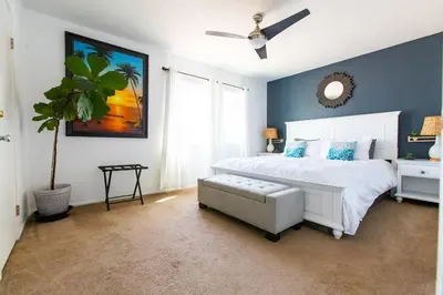 a bedroom with a white bed and a ceiling fan at Cali Condo+BBQ+MemoryFoamBeds+12min to Beach in San Juan Capistrano