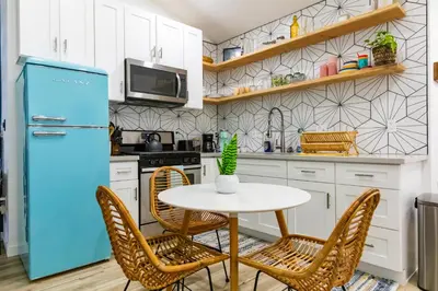 a kitchen with a table and chairs and a blue refrigerator at Stylish Casita min from the beach ! in San Juan Capistrano