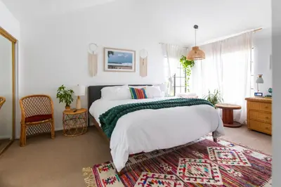 a bedroom with a bed with a green and white blanket at Private House 3 min to beach large backyard Spa Sauna BBQ ! in San Juan Capistrano
