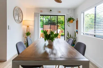 a dining room with a wooden table and chairs at Private House 3 min to beach large backyard Spa Sauna BBQ ! in San Juan Capistrano