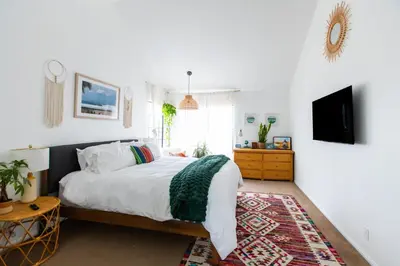 a bedroom with a bed and a tv on a wall at Private House 3 min to beach large backyard Spa Sauna BBQ ! in San Juan Capistrano