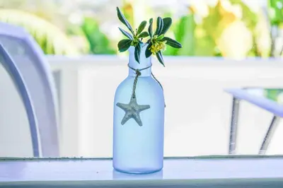 a blue vase with a flower in it on a table at STUNNINGLY PERFECT Beach ALL NEW REMODEL Galore in Laguna Beach