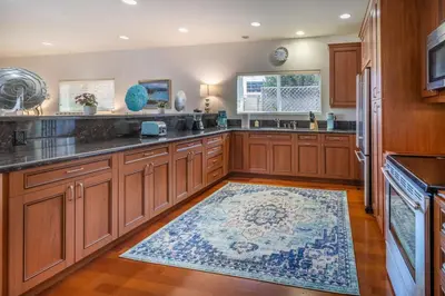 a kitchen with wooden cabinets and a rug on the floor at Stunning huge one level 1350 ft. cottage in Mission Viejo