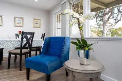 a living room with a blue chair and a table at 100 PERCENT NEW STUNNING HUGE HOME, GARDEN BEACH, RESERVED Parking in Laguna Beach