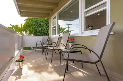 a row of chairs sitting on a porch with flowers at 100 PERCENT NEW STUNNING HUGE HOME, GARDEN BEACH, RESERVED Parking in Laguna Beach