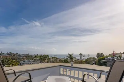 a balcony with chairs and a view of the ocean at 100 PERCENT NEW STUNNING HUGE HOME, GARDEN BEACH, RESERVED Parking in Laguna Beach