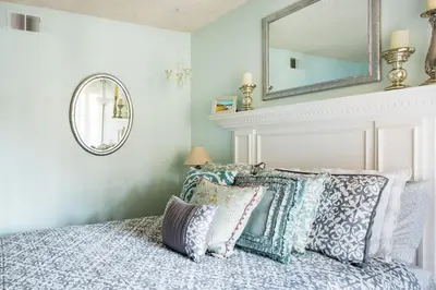 a bedroom with a bed with pillows and a mirror at Glamorous Regal Design Home with Private Patio and Garage in Laguna Hills