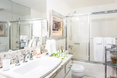 a white bathroom with a sink and a shower at Glamorous Regal Design Home with Private Patio and Garage in Laguna Hills