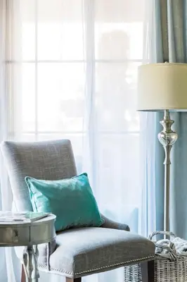 a chair with a pillow and a lamp in a room at Glamorous Regal Design Home with Private Patio and Garage in Laguna Hills