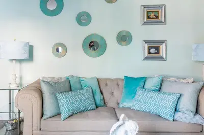 a living room with a couch with pillows on it at Glamorous Regal Design Home with Private Patio and Garage in Laguna Hills