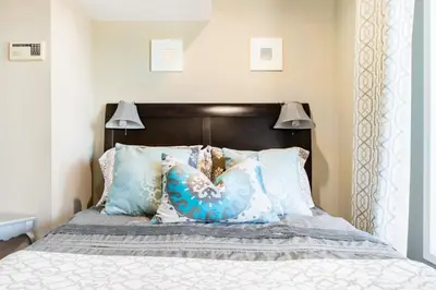 a bedroom with a bed with blue pillows at Unparalleled Villa Apartment in an Enchanting Village in Laguna Beach