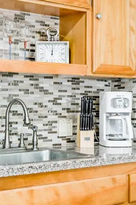 a kitchen with a sink and a clock on the wall at Unparalleled Villa Apartment in an Enchanting Village in Laguna Beach