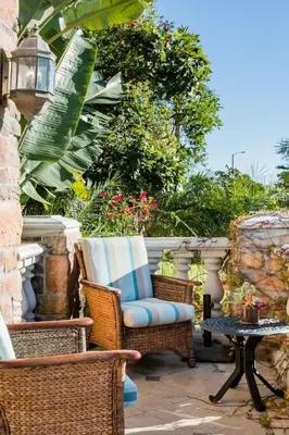a patio with wicker chairs and a table at Unparalleled Villa Apartment in an Enchanting Village in Laguna Beach