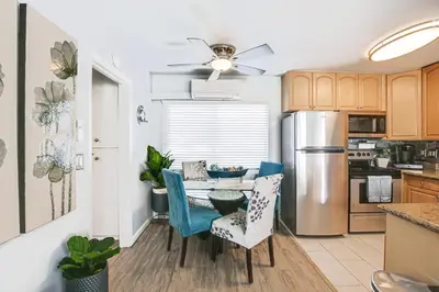 a kitchen with a table with chairs and a refrigerator at Updated Mission Beach Condo Walk to Belmont Park! in San Diego