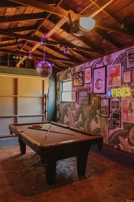 a room with a pool table in front of a wall at Balboa 6BR Mansion with Hot Tub and Game Room in San Diego