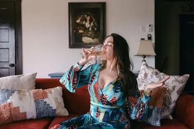 a woman sitting on a couch drinking a glass of wine at Balboa 6BR Mansion with Hot Tub and Game Room in San Diego