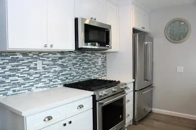 a kitchen with a stove and a microwave at Balboa Paradise - Renovated Coastal Haven in Newport Beach