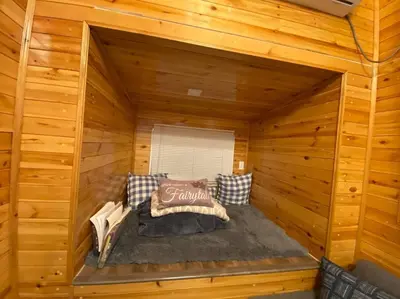 a large bed in a wooden cabin with at Tiny House - mountain views close to everything in Valley Center