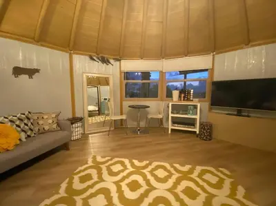 a living room with a couch and a flat screen tv at Glamping-Sky Dome Yurt-Tiny House-2 modern composting toilet in Valley Center