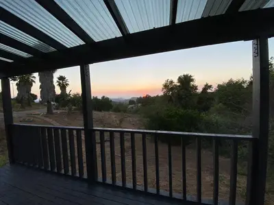 a screened in porch with a view of the sunset at Glamping-Sky Dome Yurt-Tiny House-2 modern composting toilet in Valley Center