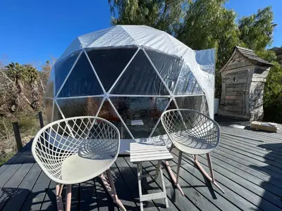 two chairs and a tent on a deck at Sunset Dome - Outdoor Shower/Composting Toilet in Valley Center