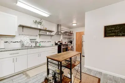 a kitchen with white cabinets and a wooden table at Perla D'Italia -1BR- FREE Driveway Parking -1 Car in San Diego