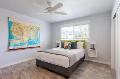 a bedroom with a bed with a map on the wall at Charming Beach Bungalows - 4BR, Sleeps 10, Pets OK in Carlsbad