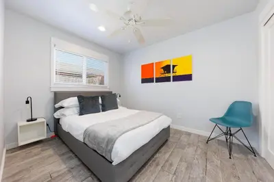 a bedroom with a bed and a blue chair at Charming Beach Bungalows - 4BR, Sleeps 10, Pets OK in Carlsbad