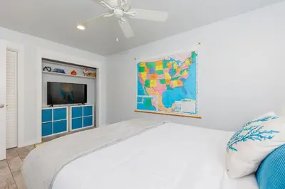 a white bedroom with a map on the wall at Charming Beach Bungalows - 4BR, Sleeps 10, Pets OK in Carlsbad