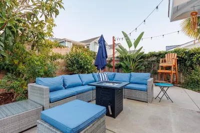 a patio with a blue couch and a table at Charming Beach Bungalows - 4BR, Sleeps 10, Pets OK in Carlsbad