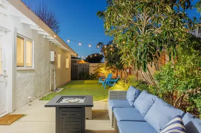 a patio with a blue couch and a table at Charming Beach Bungalows - 4BR, Sleeps 10, Pets OK in Carlsbad