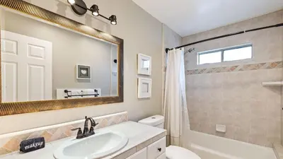 a bathroom with a sink and a toilet and a mirror at Breathtaking Meadows by AvantStay Temecula Group Retreat Pool Pickleball Firepit Hot Tub in Temecula