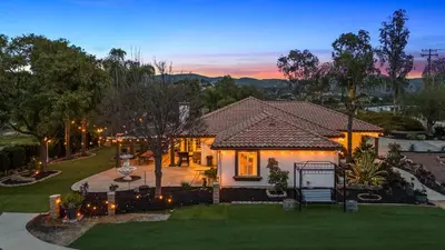 a house with lights in the yard at dusk at Breathtaking Meadows by AvantStay Temecula Group Retreat Pool Pickleball Firepit Hot Tub in Temecula