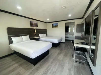 a hotel room with two beds and a television at Escondido Lodge in Escondido