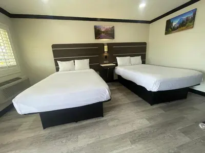 a hotel room with two beds with white sheets at Escondido Lodge in Escondido