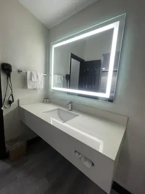 a bathroom with a sink and a large mirror at Escondido Lodge in Escondido