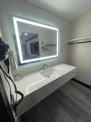 a bathroom with a sink and a large mirror at Escondido Lodge in Escondido