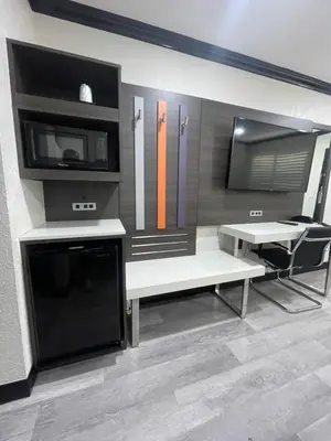 a living room with a bench and a table and a microwave at Escondido Lodge in Escondido