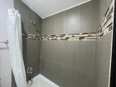 a bathroom with a shower with a tub and a sink at Escondido Lodge in Escondido