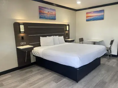 a bedroom with a large bed with a white bedspread at Escondido Lodge in Escondido